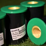 Group of Kuper K12 glue thread spools on grass, one spool lying on its side