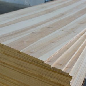 Corner close-up of stacked alder wall panels, showing the grooved edge profile and small knots.